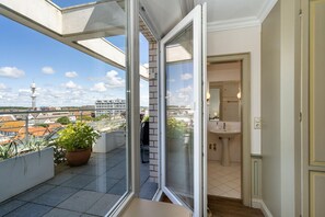 A balcony with a potted plant, a view of the cityscape, and a glimpse of a bathroom with a sink and mirror. - Penthouse F23 - Penthouse for 7 people with a unique view over Sylt, (Sylt)