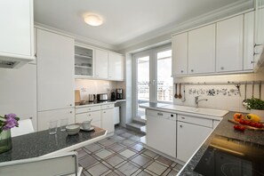 A modern kitchen with white cabinets, a granite countertop, a built-in dishwasher, and a window providing natural light. - Penthouse F23 - Penthouse for 7 people with a unique view over Sylt, (Sylt)