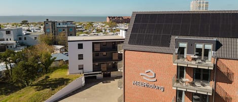 A modern building with a brick facade and a sign reading 'MEERholung.'