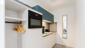 A compact kitchen with a built-in oven, a coffee maker, and a microwave. - MEERholung Vacation Rental 3.6 with Balcony for up to 5 Guests, 400 m from the Sea - House (Cuxhaven)