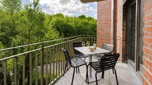 A balcony with a table, chairs, and a bottle of wine. - MEERholung Vacation Rental 3.6 with Balcony for up to 5 Guests, 400 m from the Sea - House (Cuxhaven)