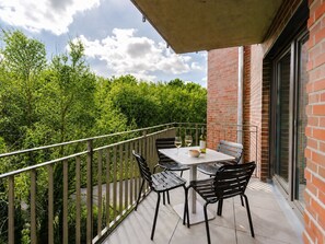 A balcony with a table, chairs, and a bottle of wine. - MEERholung Vacation Rental 3.6 with Balcony for up to 5 Guests, 400 m from the Sea - House (Cuxhaven)