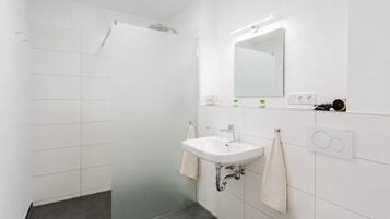 Ein modernes Badezimmer mit Dusche, Waschbecken und Toilette.