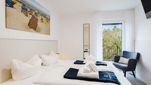 A hotel room with a bed, a chair, a painting, a window, and a balcony. - MEERholung Vacation Rental 3.6 with Balcony for up to 5 Guests, 400 m from the Sea - House (Cuxhaven)