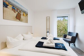 A hotel room with a bed, a chair, a painting, a window, and a balcony. - MEERholung Vacation Rental 3.6 with Balcony for up to 5 Guests, 400 m from the Sea - House (Cuxhaven)