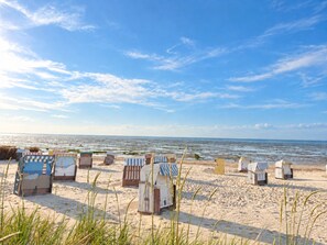 A beach with several beach huts and a clear view of the ocean. - MEERholung Vacation Rental 3.6 with Balcony for up to 5 Guests, 400 m from the Sea - House (Cuxhaven)