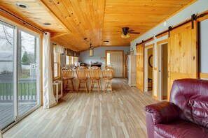 A wooden interior with a dining area, a sofa, and a kitchen. - 'Eagles Rest' Peaceful Cottage on Lake Champlain (Chazy)