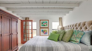 A bedroom with a large bed, wooden wardrobe, and two framed artworks on the wall. - 2 Mi to St Lucie Access! Stuart Getaway w/ Patio (Stuart)