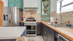 A kitchen with a stainless steel refrigerator, a stove, an oven, a sink, and teal cabinetry. - 2 Mi to St Lucie Access! Stuart Getaway w/ Patio (Stuart)