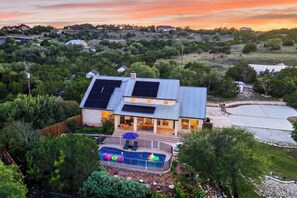 Ein Haus mit Pool, Solaranlage und Blick auf die umliegende Landschaft.