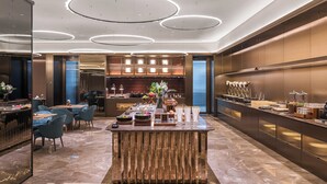 Eine moderne Hotelhalle mit einer zentralen Bar, einer Sitzecke und einer Rezeption.
