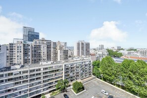 Ein mehrstöckiges Gebäude mit Balkonen, einem Parkplatz und blauem Himmel.
