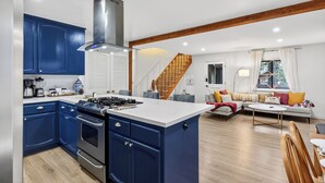 Una cocina moderna con armarios azules, una isla central y una estufa integrada.