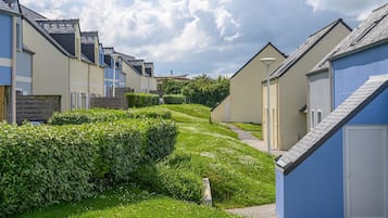 Une rangée de maisons modernes, de plain-pied, avec une pelouse bien entretenue et un chemin.