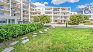 A multi-story hotel with balconies, a well-maintained lawn, and a clear sky. - Stay with Indoor Pool & Sea (Plougonvelin)