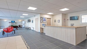 A reception area with a counter, chairs, a pool table, and a television. - Beach Flat with Pool (Plougonvelin)