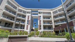 A multi-story building with balconies, a central courtyard, and a clear blue sky. - Coastal Stay for 4 in Cagnes-sur-Mer (Cagnes-sur-Mer)