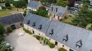 A stone building with multiple roof levels and a gravel courtyard. - 5 bedroom amazing home in Combrit - St Marine (Combrit - St Marine)