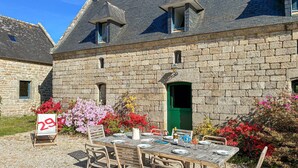 A stone building with a green door, a table set for dining, and a sign with the number 29. - 5 bedroom amazing home in Combrit - St Marine (Combrit - St Marine)