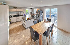A modern kitchen with a dining area, large windows, and a view of the outdoors. - Awesome home in Châteauneuf-Grasse (Châteauneuf-Grasse)