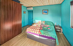 A bedroom with a bed, a wooden wardrobe, a door, and a window. - Awesome home in Châteauneuf-Grasse (Châteauneuf-Grasse)