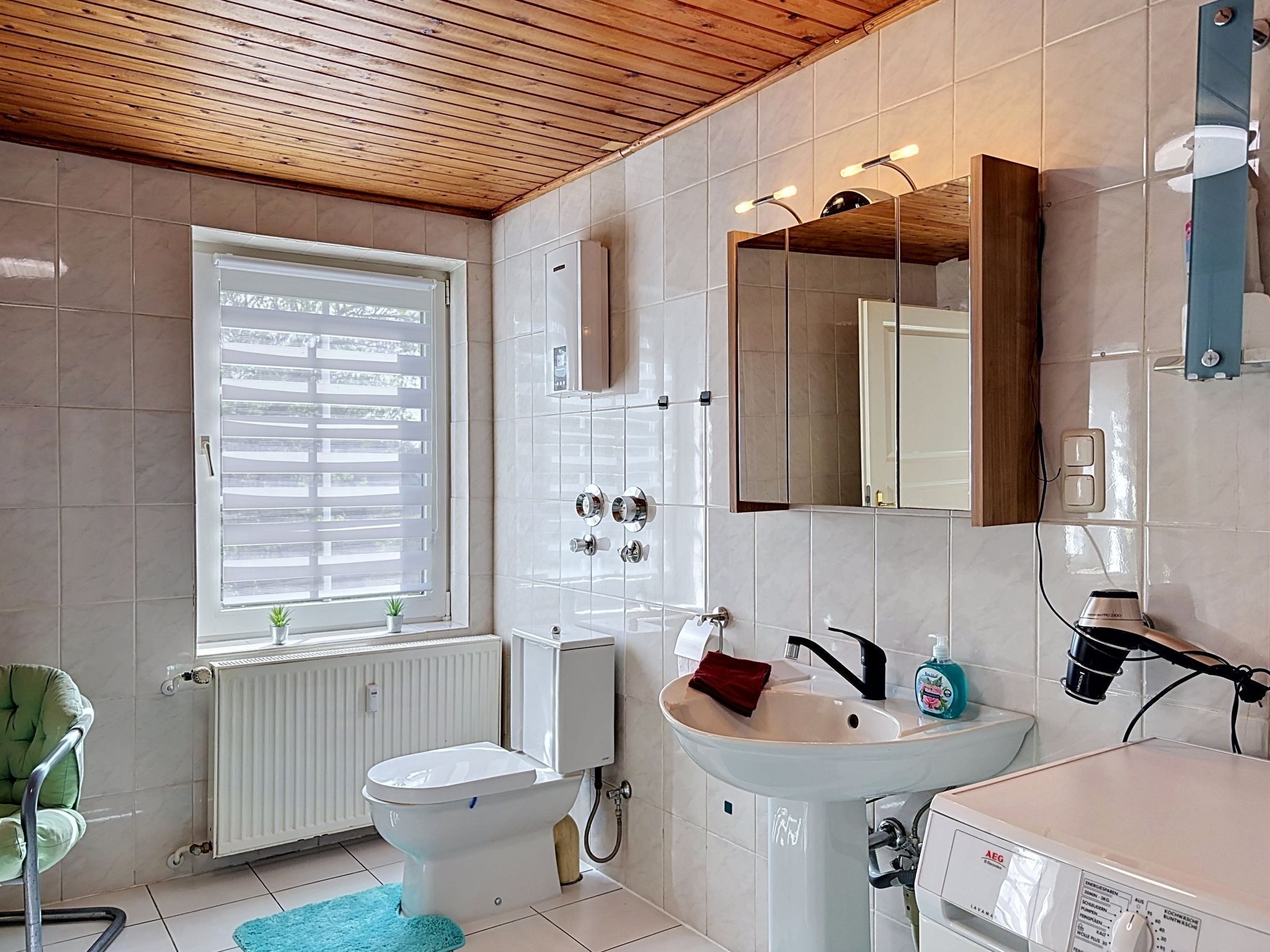 Un baño moderno con inodoro, lavamanos y espejo.