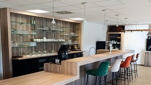 A modern bar area with a wooden counter, glass shelves, and bar stools. - Cabin near Meyrignac Lake (MEYRIGNAC  L'EGLISE)