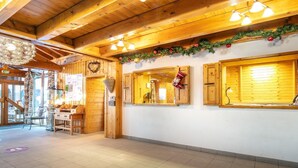 Un intérieur en bois avec un plafond haut, un lustre et une guirlande de Noël.
