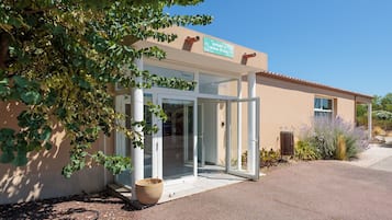 A building with a sign reading 'SPORT & BIEN-ETRE' and a glass door entrance.
