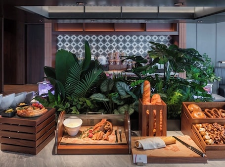 A buffet setup with various food items, including bread, pastries, and a bowl of soup.. IntercityHotel Guangzhou Chimelong
