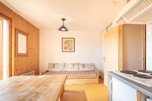 Habitació compacta amb una panxa de fusta, una taula, una placa de cocció i un quadre amb marc a la paret.
