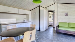 Una cuina moderna amb zona de menjador, un sofà i un rellotge a la paret.