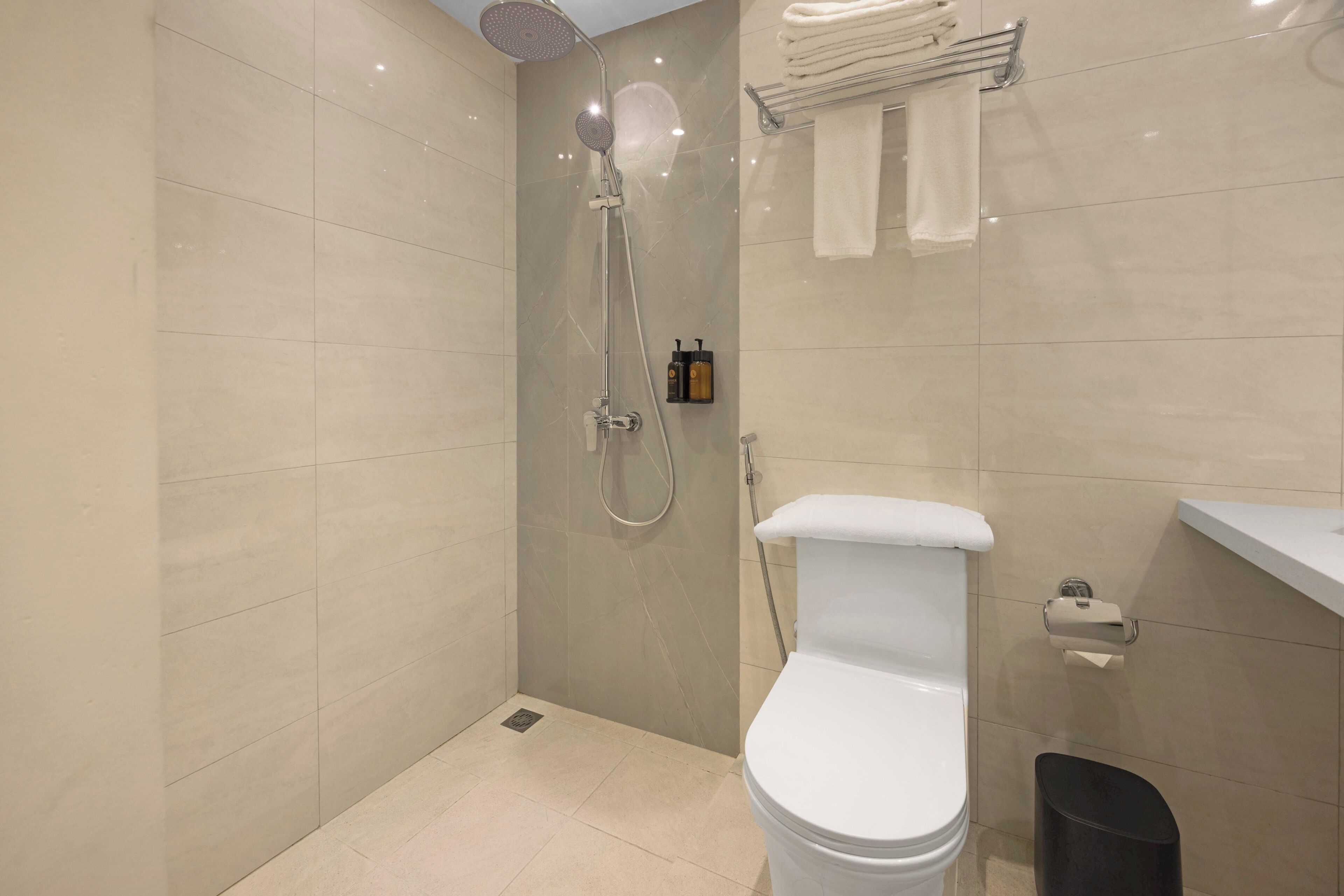 Un bagno moderno con doccia, WC e porta asciugamani.