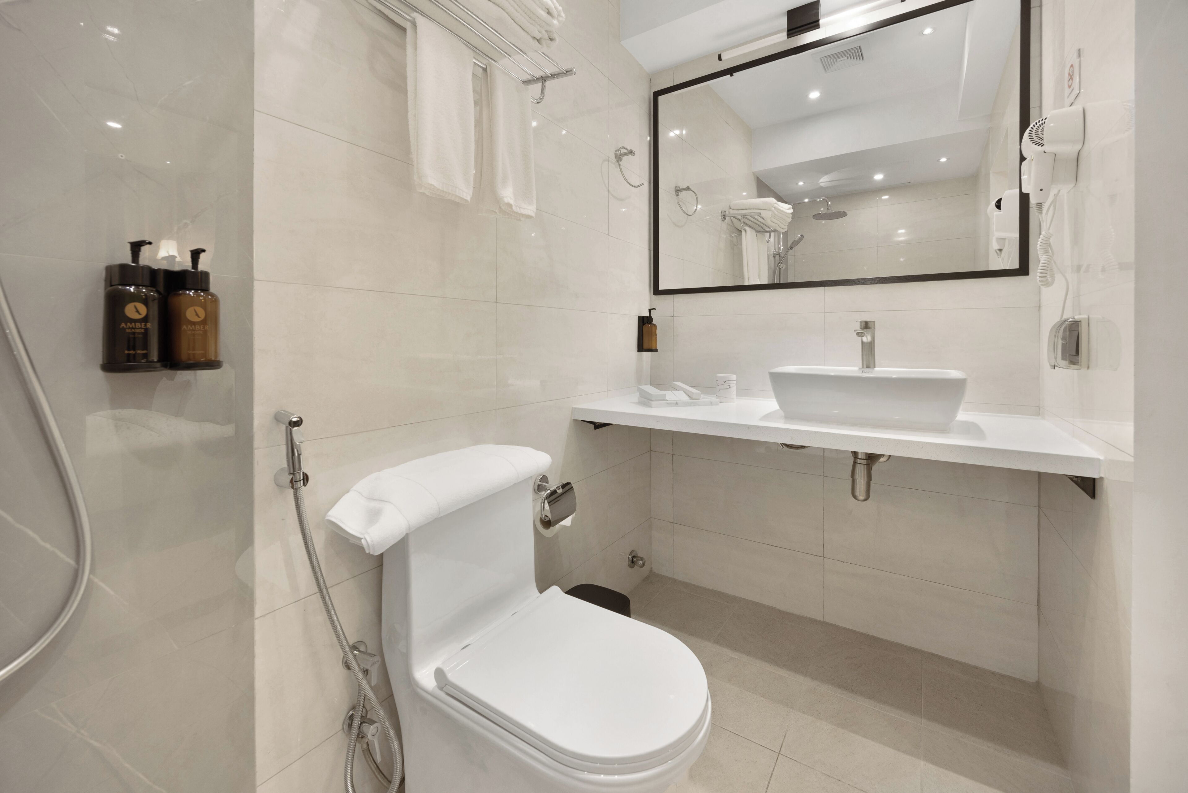 Un bagno moderno con il water, lavandino e doccia.