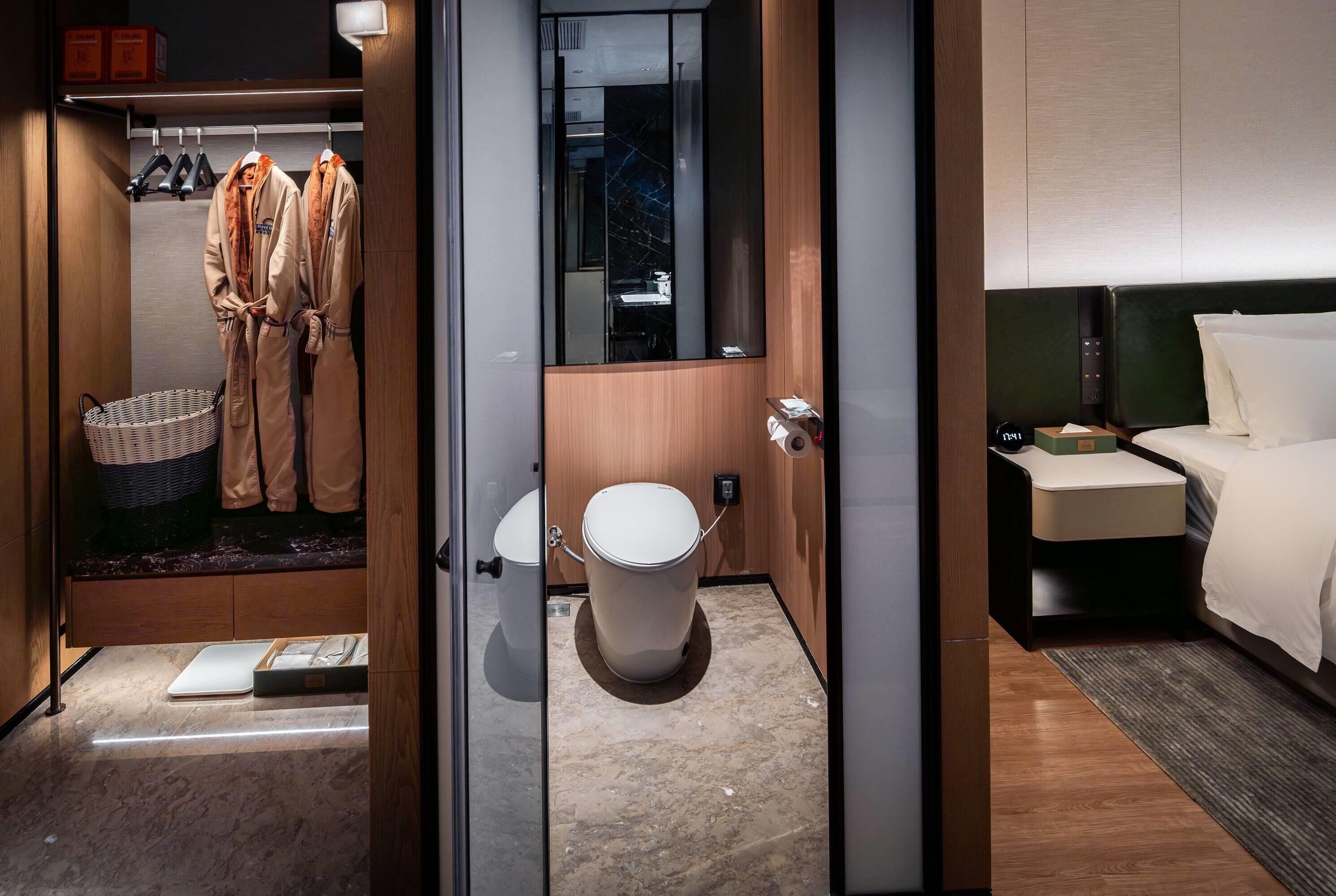 A modern bathroom with a toilet, bidet, and a mirror.