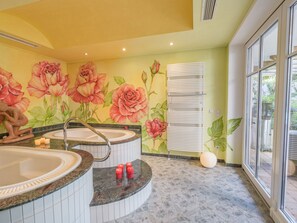 Ein Badezimmer mit zwei Waschbecken, einer großen Blumenmalerei und einem Fenster mit Jalousien.