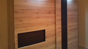 Eine Wandpaneele aus Holz mit eingebautem Regal und einer vertikalen schwarzen Platte.