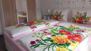 Een slaapkamer met een bed, een kledingkast en een nachtkastje.