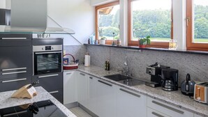 Una cucina moderna con forno integrato, lavello e piano di lavoro.