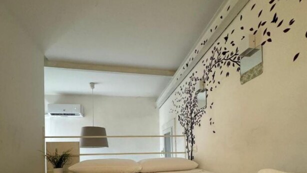 Un dormitorio con cama, toallas, un espejo montado en la pared y una ventana.
