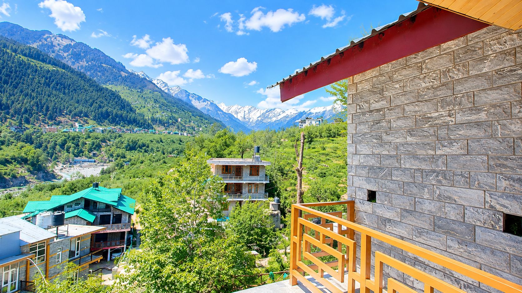 A mountain view with a stone building and a green-roofed structure.