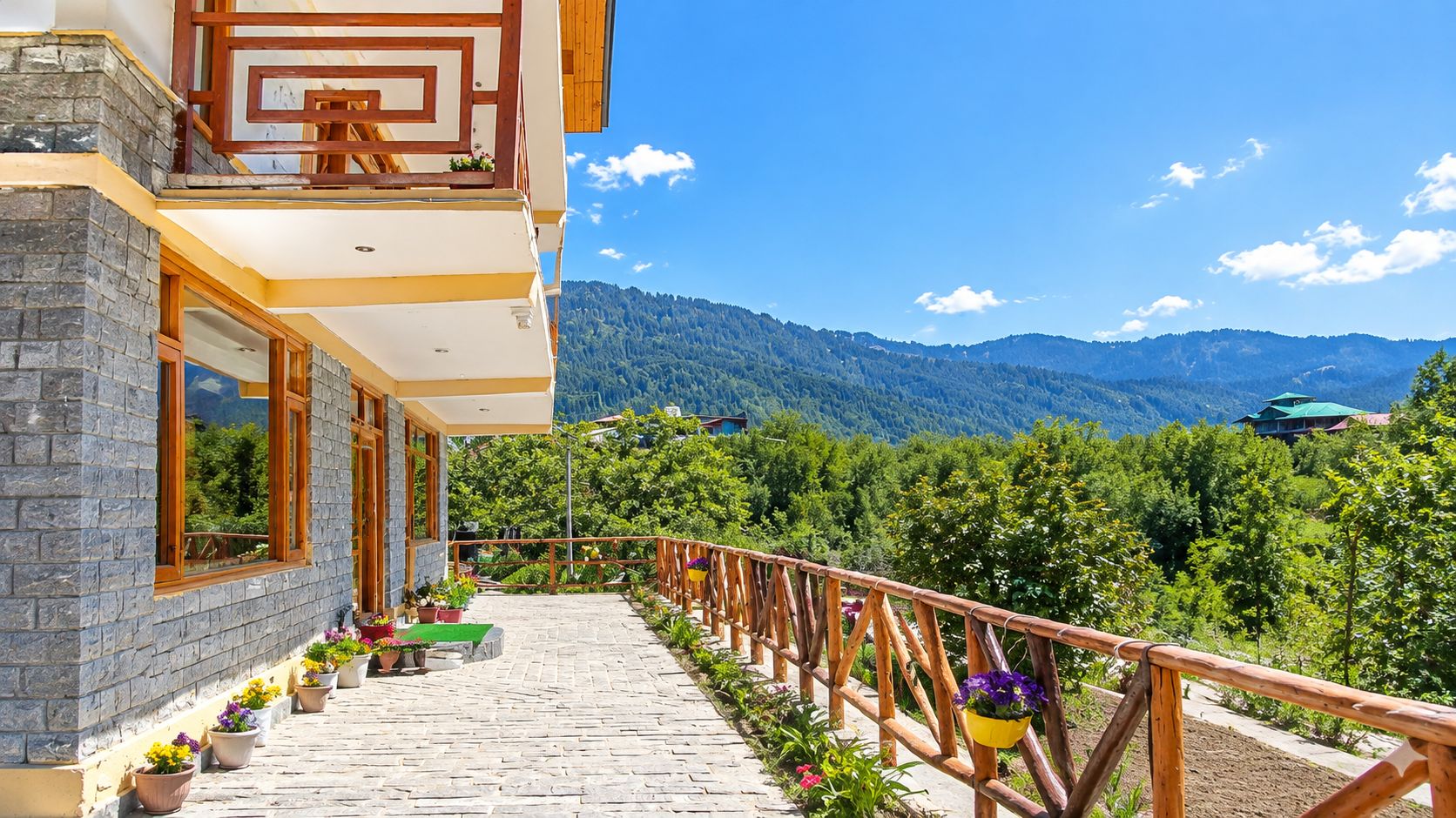 Ein Gebäude mit einem Balkon, der auf eine gebirgige Landschaft blickt.