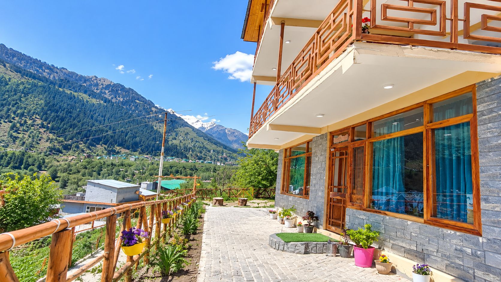 Ein Hotel mit einem Balkon mit Blick auf eine gebirgige Landschaft.