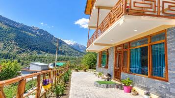 Ein Hotel mit einem Balkon mit Blick auf eine gebirgige Landschaft.