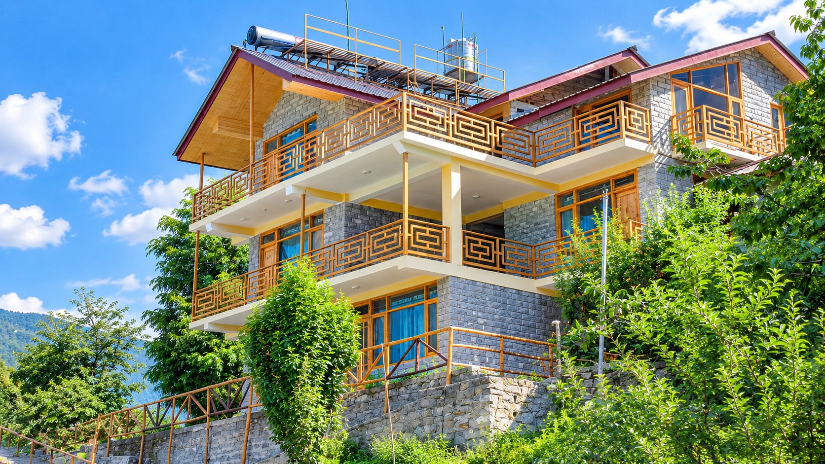 A multi-story building with balconies, stone walls, and a clear sky.