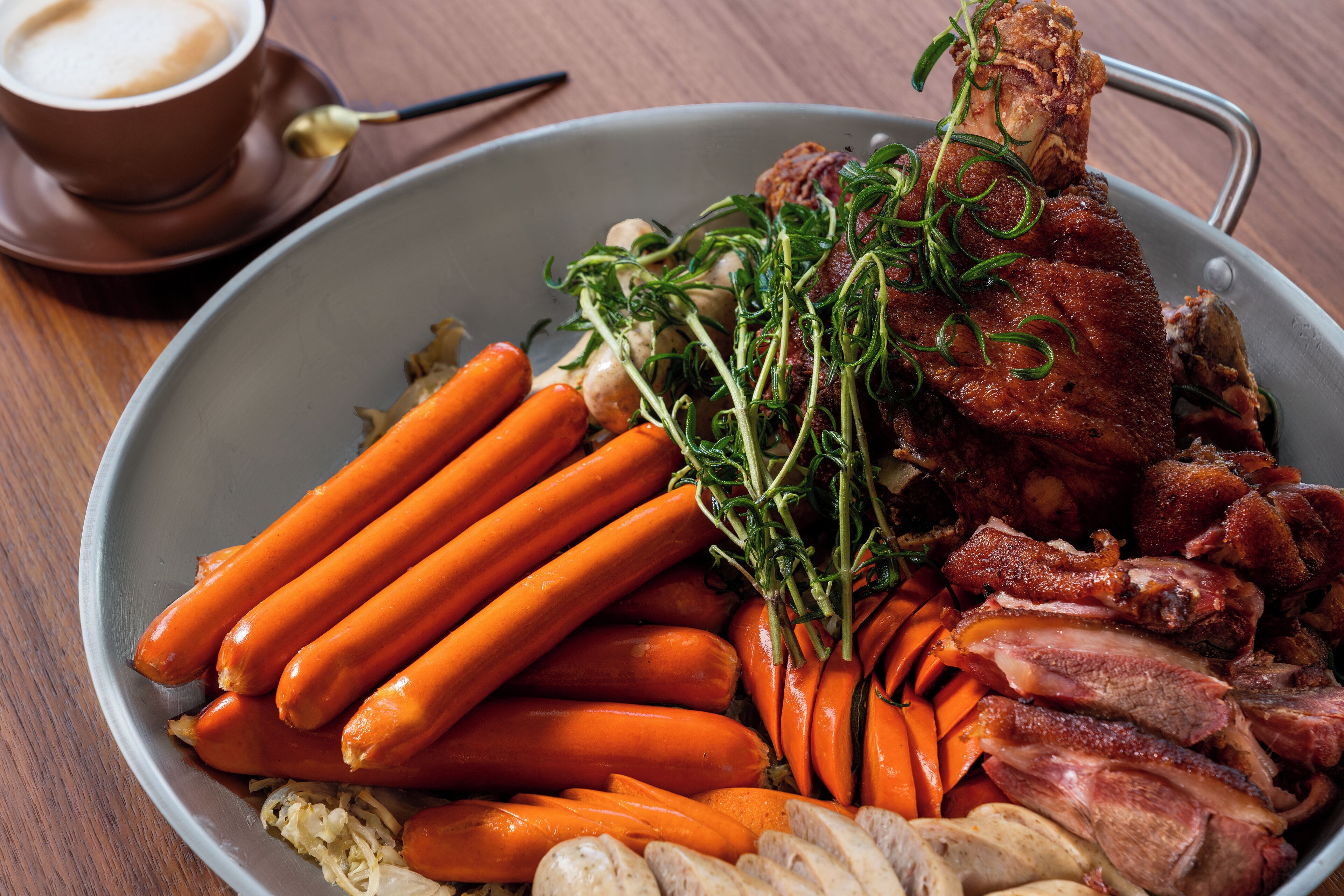 A plate of food with carrots, meat, and herbs.