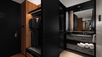 Un baño moderno con un espejo grande, un lavamanos y un perchero para toallas.