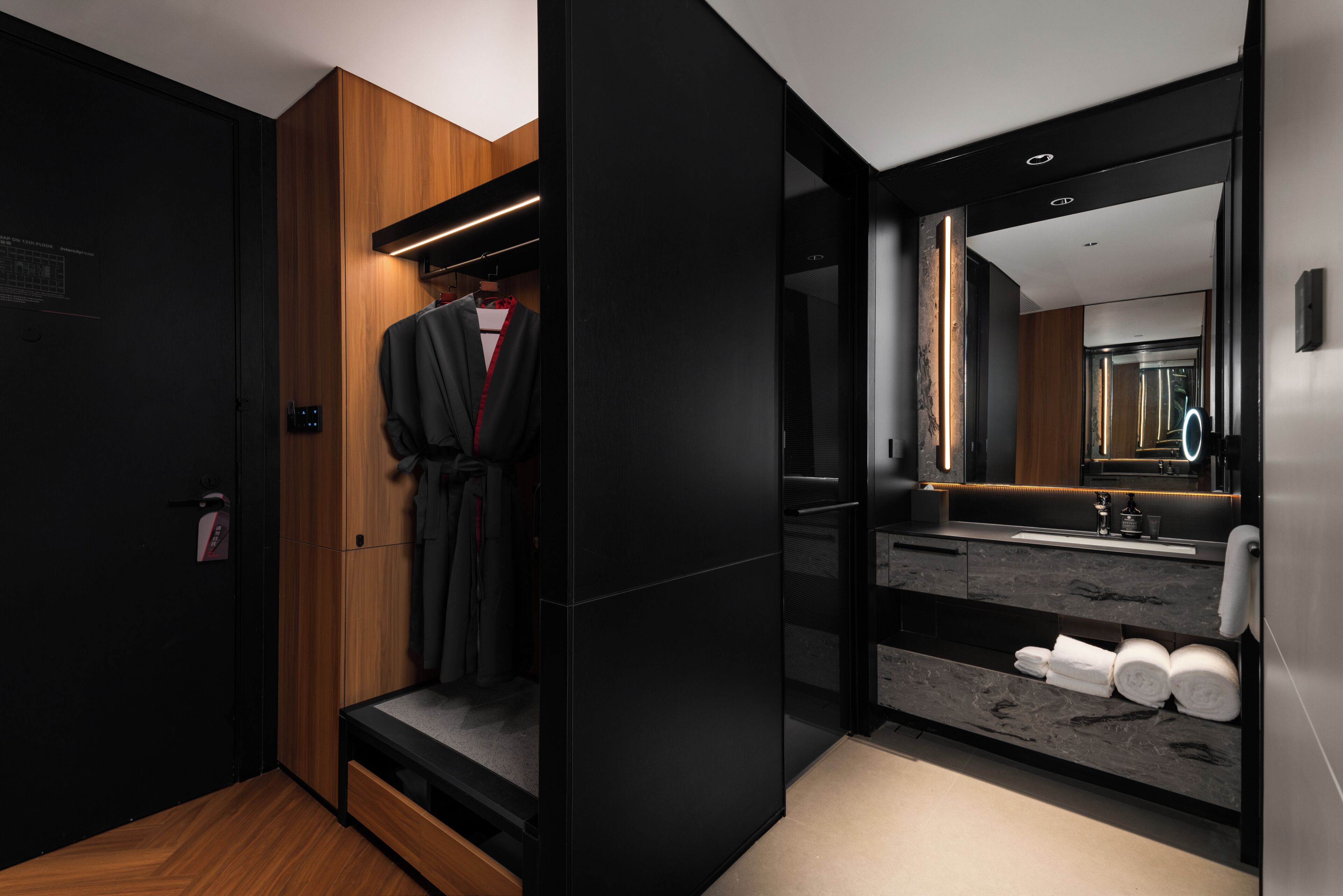 A modern bathroom with a large mirror, a sink, and a towel rack.