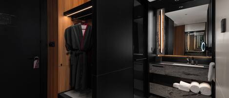 A modern bathroom with a large mirror, a sink, and a towel rack.