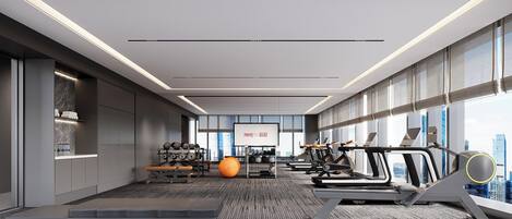 Un gimnasio moderno con cintas de correr, pesas y pelotas de ejercicio.
